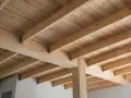 Widok na solidny dębowy strop z widocznymi belkami i deskami. Konstrukcja tworzy naturalny, ciepły klimat.