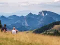 Para odpoczywa na trawiastym wzgórzu, podziwiając malownicze góry. To idealne miejsce na odkrywanie szczawnickich atrakcji.