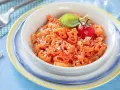 Makaron w kształcie zwierzątek z sosem pomidorowym, posypany parmezanem, udekorowany pomidorkiem i bazylią.