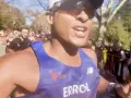 En löpare i blått linne, med texten "ERROL", kämpar på för att springa marathon. Publiken hejar längs banan.