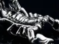 Metalowy symbol skorpiona, z detalami odwzorowującymi jego pancerz i szczypce.