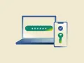 Laptop z polem na hasło i telefon z kluczem symbolizującym zabezpieczenie 2FA.