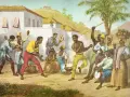 Grupa ludzi tańczy i śpiewa, tworząc rytm do capoeira. To taniec, sztuka walki i muzyka w jednym.