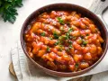 Fagioli in salsa rossa, guarniti con prezzemolo fresco. Un piatto saporito che si possono cuocere all'uccelletto.