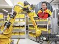 Zautomatyzowany magazyn DHL, duża giełda niemiecka, z robotem i uśmiechniętym menedżerem.