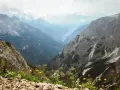 Widok z górskiej ścieżki na dolinę. Czy dolomity to Alpy? Tak, te skaliste szczyty i zielone doliny wyglądają jak Alpy.