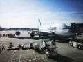 Lufthansa A380 na płycie lotniska we Frankfurcie. W tle widać inne samoloty i budynki terminali, typowe dla lotnisk w Niemczech.