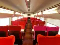 Rows of red and pink seats inside a train car, ready for passengers on the best train from Amsterdam to Paris.