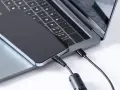 Ein iPhone wird über ein USB-C-Kabel mit einem Laptop verbunden, um Fotos zu übertragen.