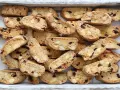 Un vassoio pieno di croccanti biscotti toscani, ricchi di mandorle e mirtilli rossi, pronti per essere inzuppati.