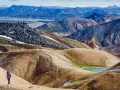 Un randonneur solitaire explore les paysages colorés et volcaniques de Landmannalaugar, un trek inoubliable en Islande.