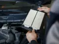 Hände halten einen gebrauchten Luftfilter. Ein guter Zeitpunkt, um sich zu fragen, wie oft innenraumfilter wechseln.