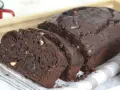 Bizcocho de platano y chocolate, recién horneado y cortado en rebanadas, con trozos de nuez visibles.