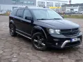 Czarny Dodge Journey 3.6 zaparkowany na placu z kostki brukowej. W tle budynki i inne samochody.
