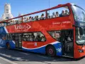 Tourists enjoy a hop on hop off bus tour of Madrid, Spain, with the iconic Turibus double-decker bus.