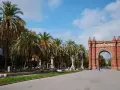 Łuk Triumfalny w Barcelonie, z rzędem palm i błękitnym niebem, to ikoniczne miejsce, które podkreśla wspaniałe barcelona położenie.