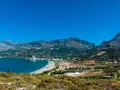 Malownicza zatoka z piaszczystą plażą i górami w tle. Urokliwe plaze Kreta zapraszają do odpoczynku.
