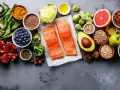 Zdrowe składniki na dietę na stłuszczoną wątrobę: łosoś, jagody, awokado, orzechy, warzywa i nasiona.