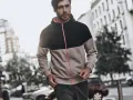 Mężczyzna w dwukolorowej bluzie z kapturem i dresach. Stylowa kurtka do dresów, idealna na miejski spacer.