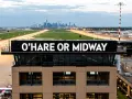 Wieża kontroli lotów na lotnisku Chicago z napisem "O'HARE OR MIDWAY". W tle widać panoramę miasta.