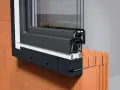 Przekrój okna z widoczną obróbką listwy startowej, izolacją i mocowaniem do ściany z pustaków.