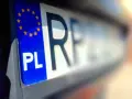 Zbliżenie na polską tablicę rejestracyjną z symbolem UE. Litery "PL" i fragment numeru rejestracyjnego są wyraźne.