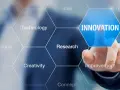 Dłoń dotyka ekranu z napisem "INNOVATION", otoczonego przez sześciokąty z hasłami: Idea, Technology, Research, Creativity, Invention, Improvement. To wizualizacja procesu, który może być częścią wzornictwo przemysłowe studia.