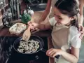 Mała kucharka smaży pieczarki na patelni. Czy dzieci mogą jeść pieczarki? Tak, to zdrowy dodatek do posiłków!