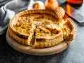 Une quiche lorraine dorée, prête à être dégustée. La cuisson est parfaite, la pâte croustillante et la garniture onctueuse.