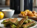 Zucchine in friggitrice ad aria senza pangrattato, croccanti e dorate, pronte per essere gustate.