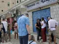 Ludzie stoją przed biurem Yemenia Airways. Czy Jemen jest bezpieczny? To pytanie zadają sobie podróżni, obserwując codzienne życie w tym kraju.