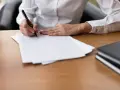 Ręka pisze piórem na białej kartce. Czy to umowa cywilnoprawna?