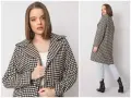 Elegancki płaszcz w klasyczną pepitkę, idealny na jesienne dni. Modelka prezentuje go z jeansami i botkami.