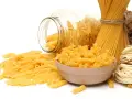 Różne rodzaje makaronu: penne, fusilli w miseczce, spaghetti nr 5 i spaghettini.