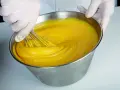 Mani guantate montano una crema pasticcera perfetta, come insegna Iginio Massari. La consistenza è vellutata e il colore giallo intenso.