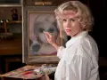 Margaret Keane målar en flicka med stora ögon och en siamesk katt.