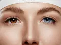 Oczy z heterochromią: jedno brązowe, drugie niebieskie. Delikatna opaska na głowie.