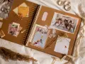 Otwarta księga wspomnień, gdzie co to jest scrapbooking widać na zdjęciach z wesela, ozdobiona wstążkami i suszonymi kwiatami.
