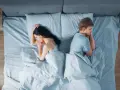Ein Paar liegt im Bett, jeder auf seiner Seite, die Rücken einander zugewandt. Getrennte Schlafzimmer – der Anfang vom Ende?