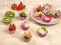 Fruktbitar doppade i choklad och vit choklad, serverade i färgglada cupcake formar. Jordgubbar, kiwi och apelsin.