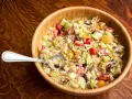 Orzo z szynką, pomidorkami, ogórkiem i fetą w drewnianej misce. Idealna sałatka na lato.