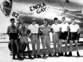 Siedmiu mężczyzn pozuje przed samolotem B-29 o nazwie "Enola Gay".