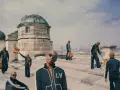 Uomini con tute Louis Vuitton e borse iconiche, un omaggio a chi era Louis Vuitton e al suo impero.
