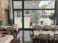 Restaurant interior with tables set for dining, featuring a mural of Milan's skyline.