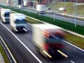 Ciężarówki na autostradzie, rozmyte przez ruch. Kierowcy potrzebują pauzy, by odpocząć od długiej jazdy.