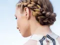 Peinados con trenzas: una mujer con un recogido trenzado elegante, ideal para un día soleado.