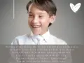 Uśmiechnięty chłopiec w białej koszuli, gotowy na Pierwszą Komunię. Krótkie życzenia na komunię: "Niechaj Jezus będzie dla Ciebie wzorem".