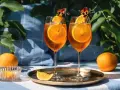 Dwa kieliszki Aperol Spritz z plastrami pomarańczy i kwiatami. Czy aperol można pić sam? Tak, ale najlepiej smakuje w towarzystwie!