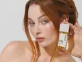 Ruda kobieta z niebieskimi oczami prezentuje perfumy "Made in Lab". Opinie o nich są zachęcające.