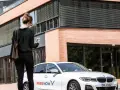 Frau mit Smartphone wartet auf FREE NOW Fahrt. Keine Beschwerde, nur Vorfreude auf die Fahrt.